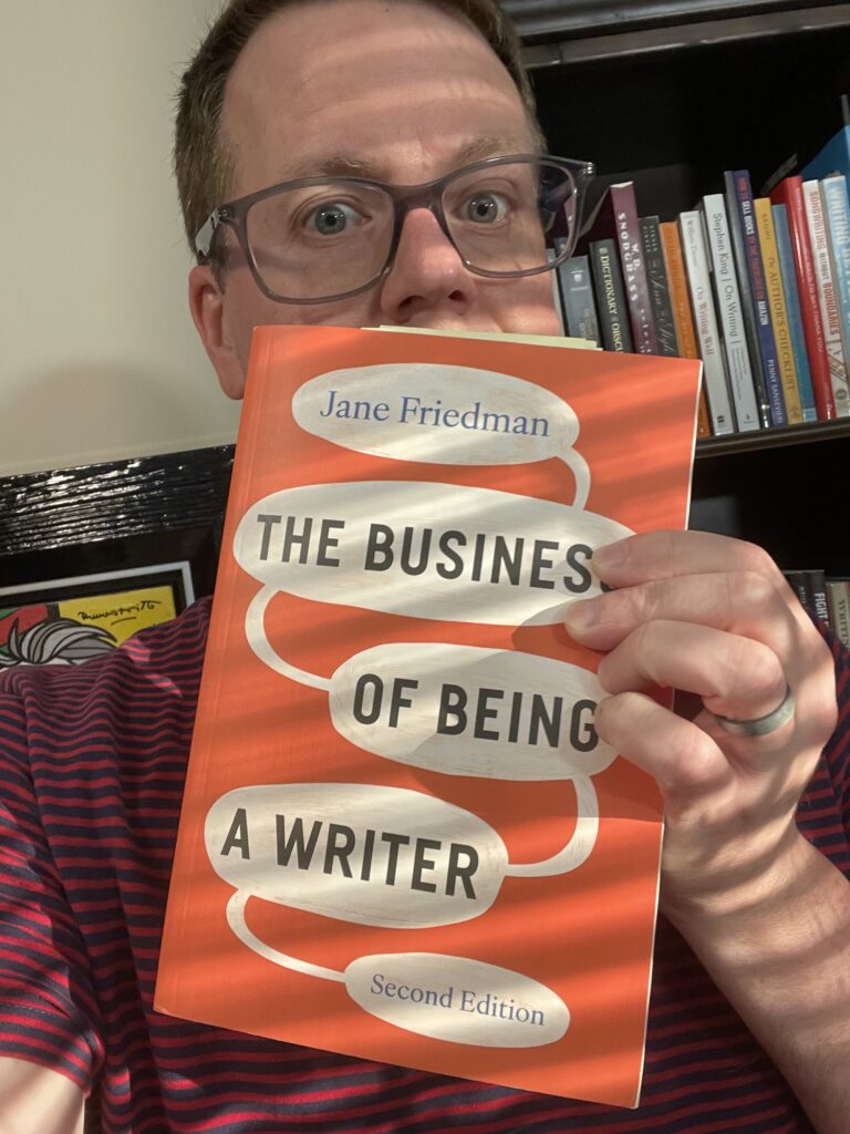 Chad S. White holding a copy of Jane Friedman's "The Business of Being a Writer"